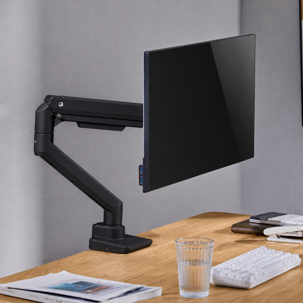 Schwarzer Monitorarm hält einen Bildschirm über einem Schreibtisch; Monitor nicht enthalten